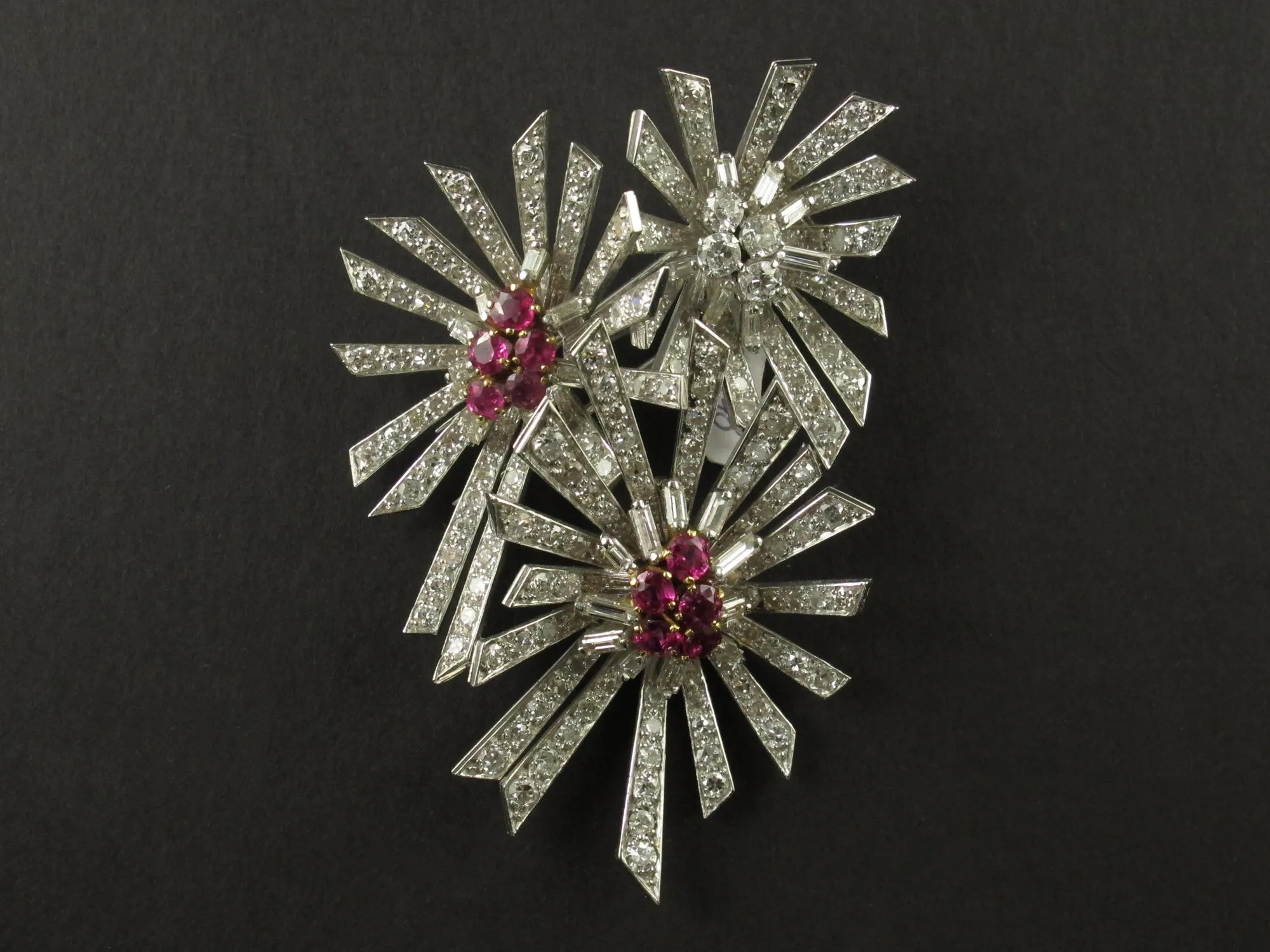 A platinum diamond and ruby flower brooch. 1940.